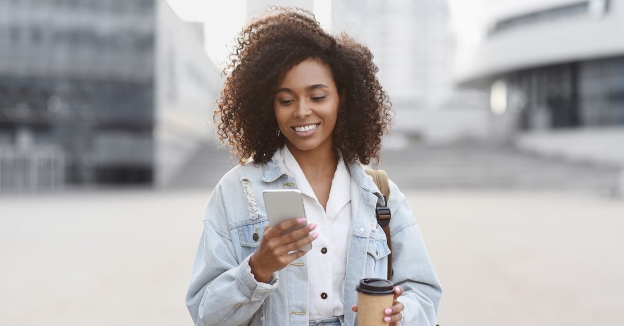 happy woman looking at smartphone message, best pieces of marital advice I've ever heard