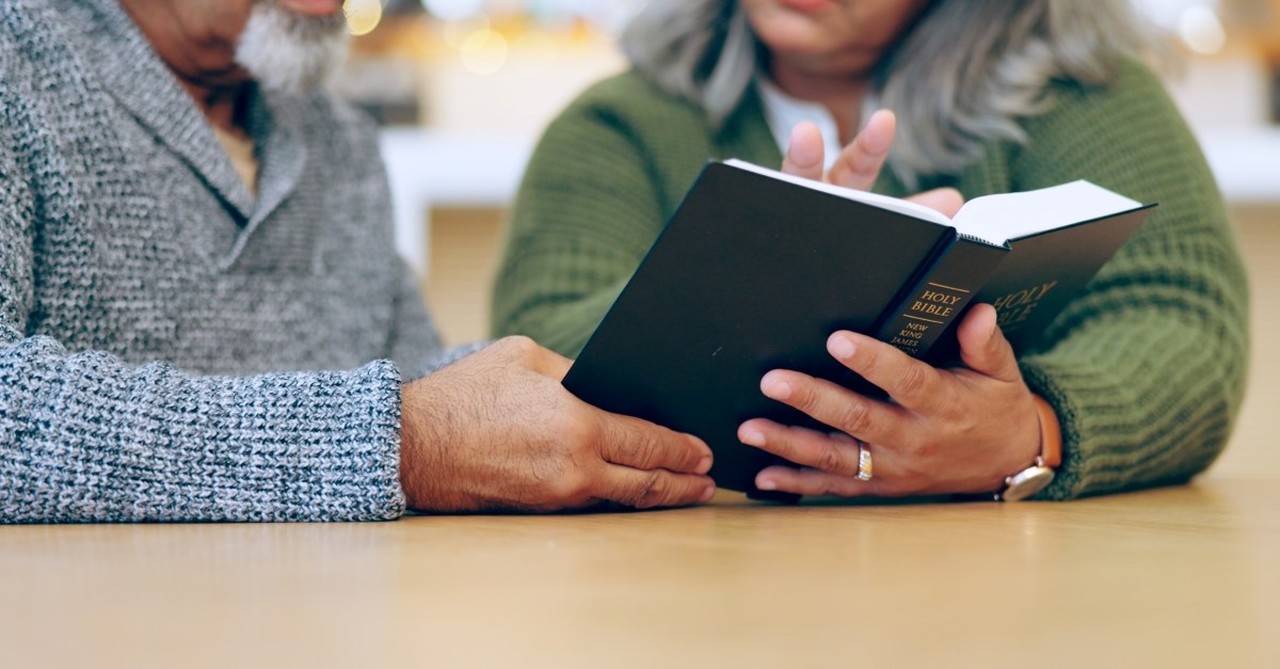 older married couple reading bible together