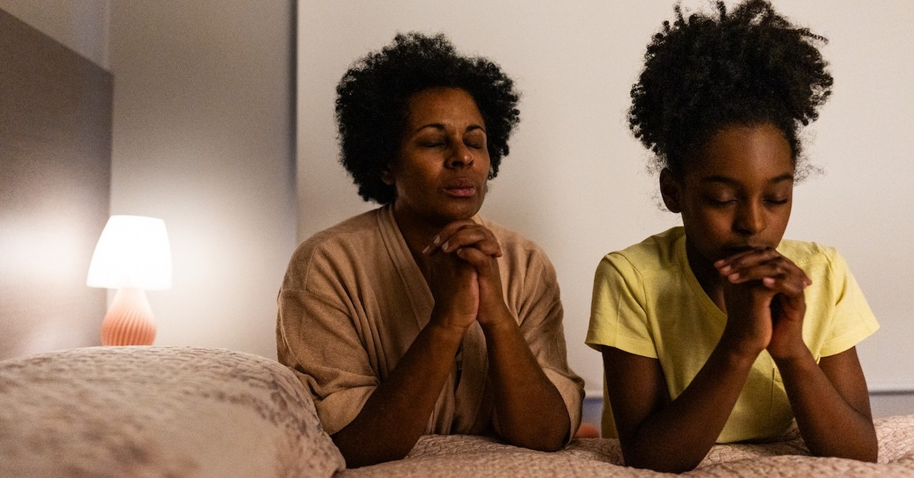 Mom and daughter praying before bed sleep