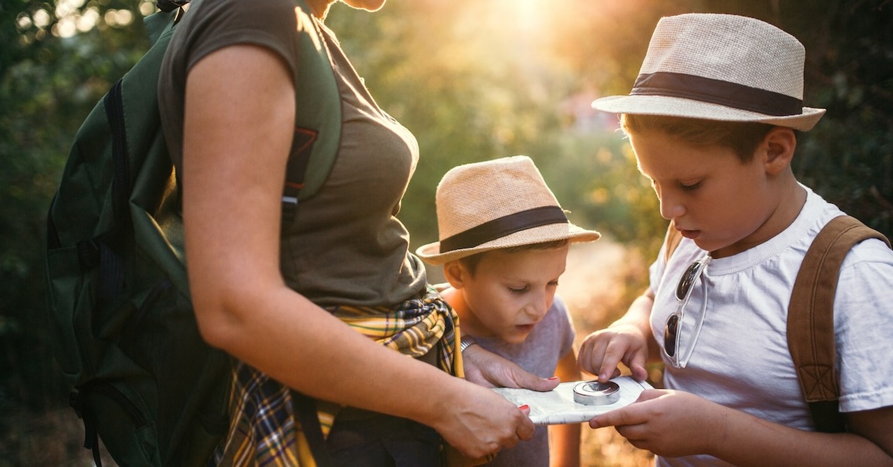 Mother and sons in nature outside treasure hunt map hiking