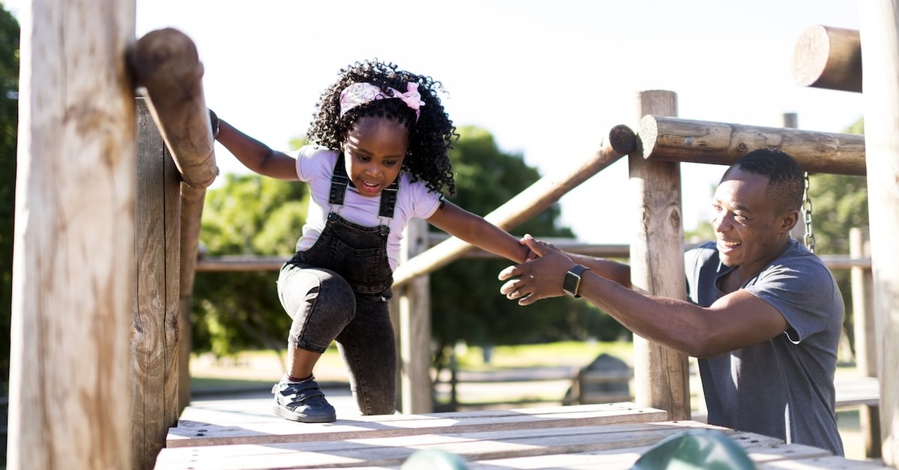 Father daughter date outside at playground in summer