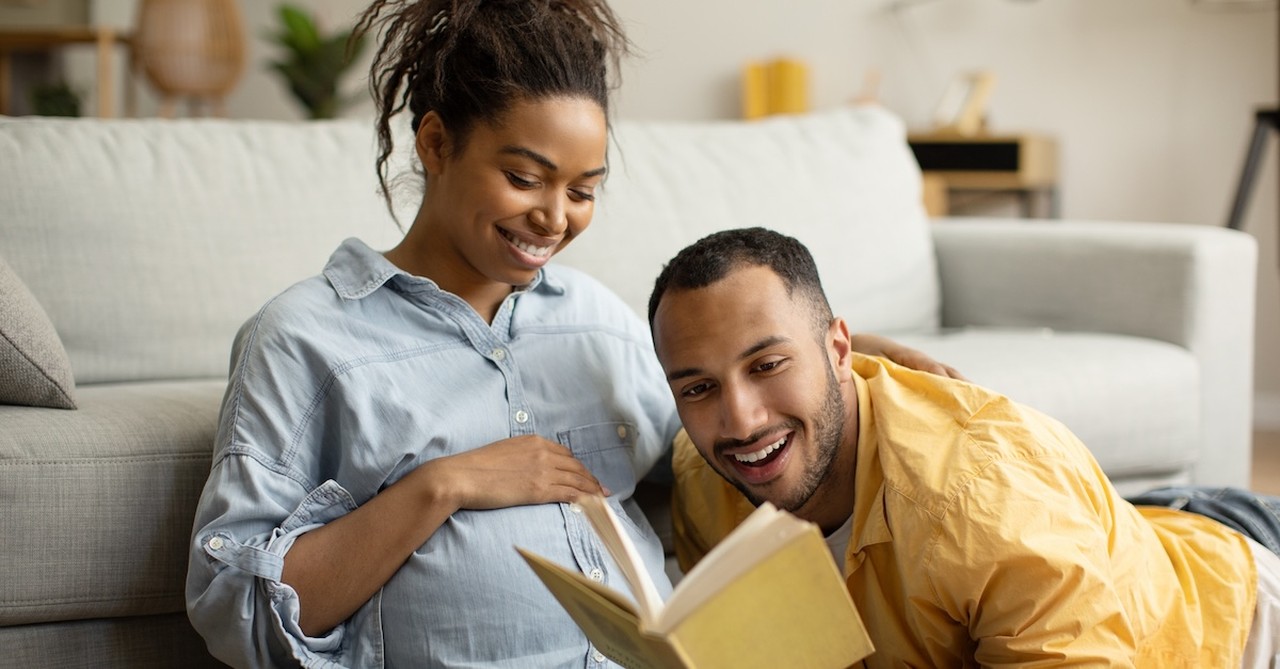 Pregnant couple reading book expectant parents