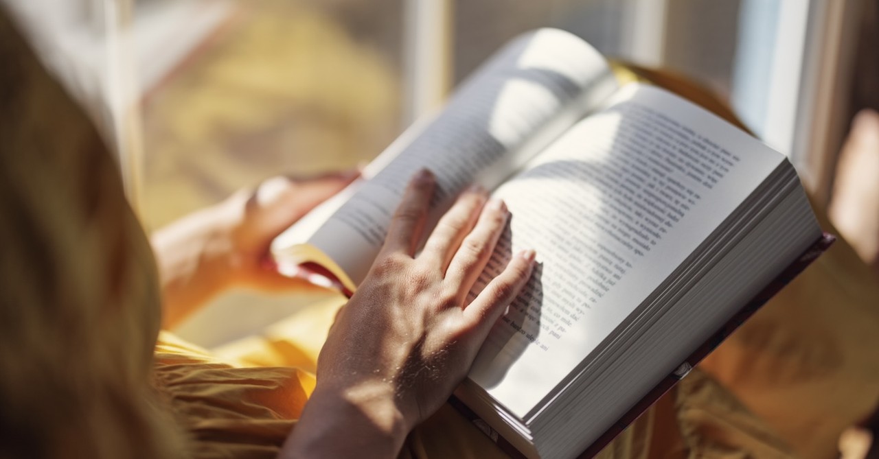 Woman reading book in window summer