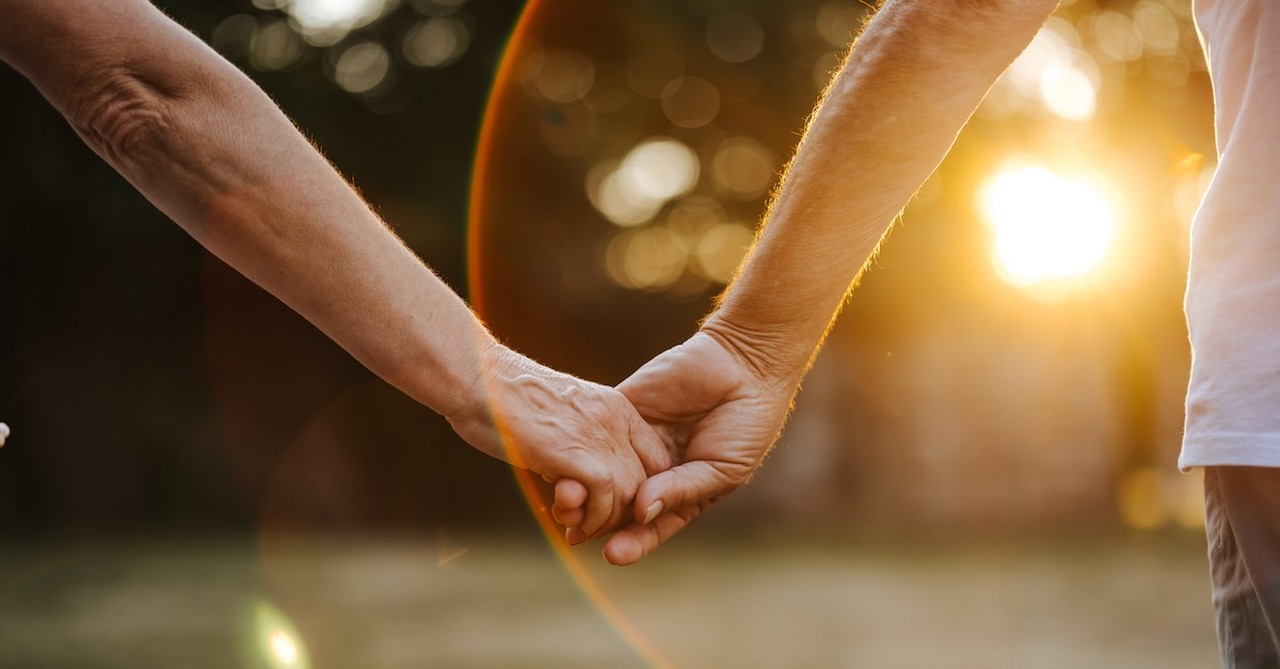 Coupe holding hands sunset