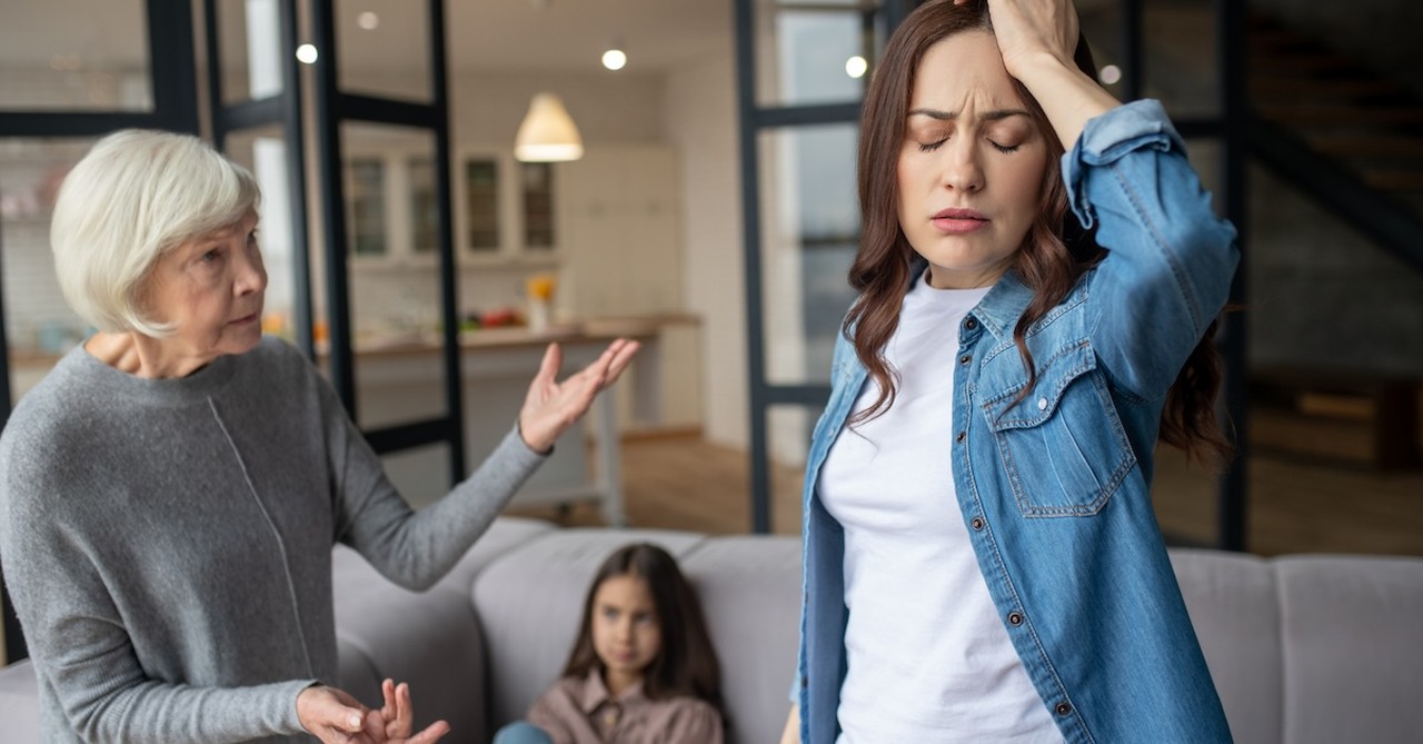 Grandmother and adult daughter arguing in front of grandchild