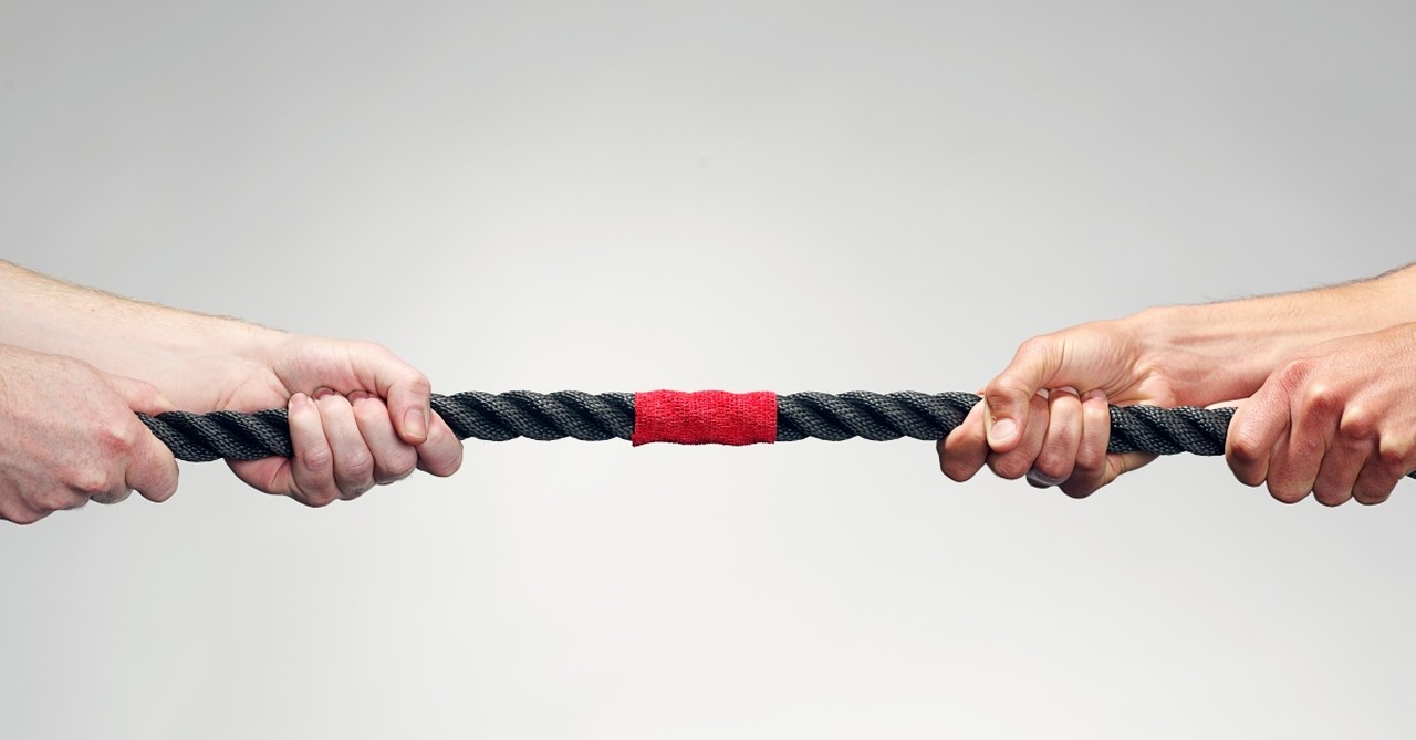 Two people pulling a rope, tug of war