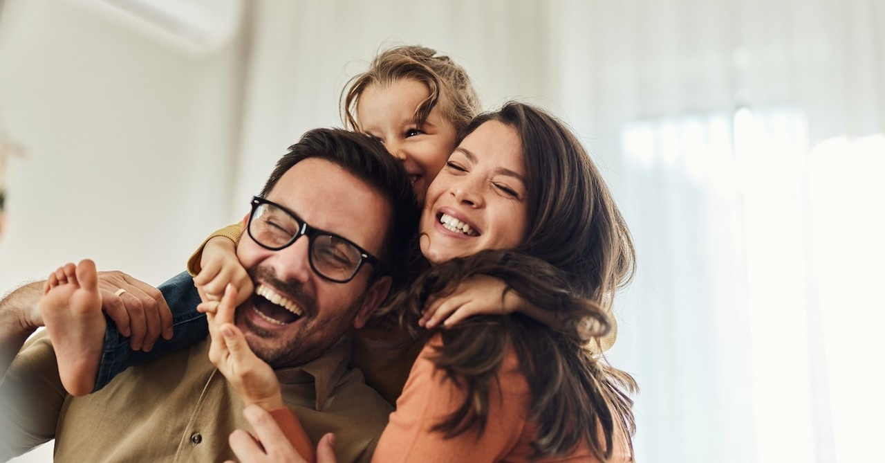 happy family hugging mom dad and daughter