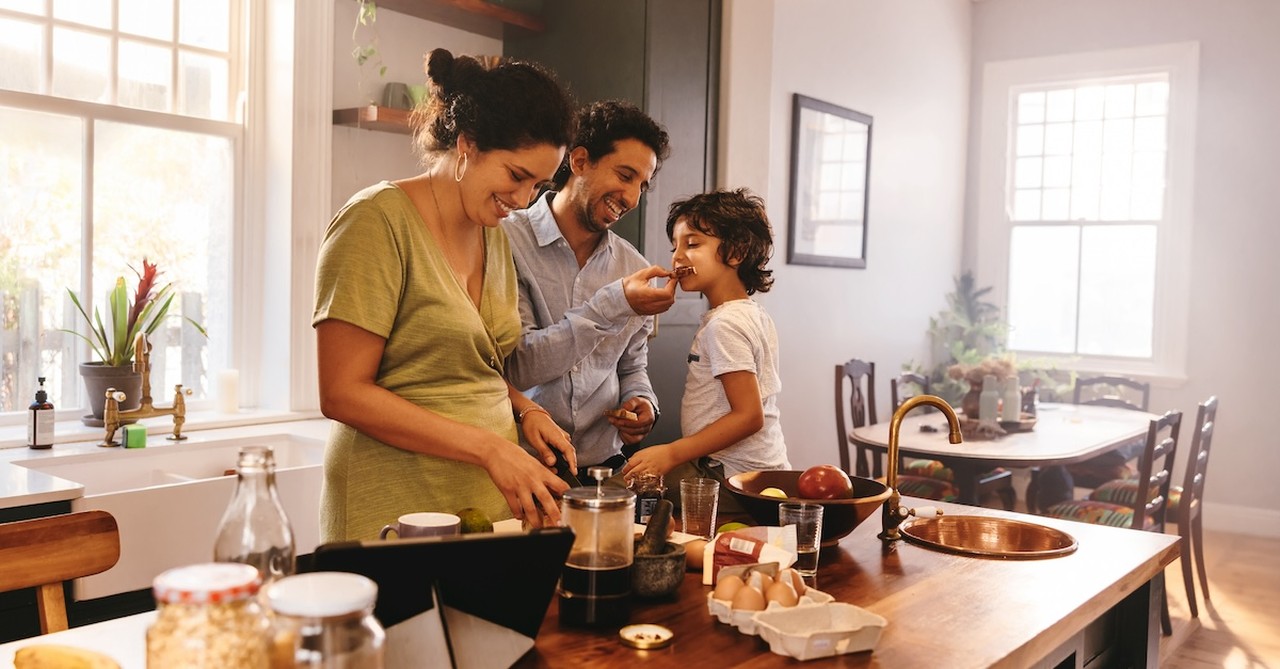 Family cooking together in kitchen with son