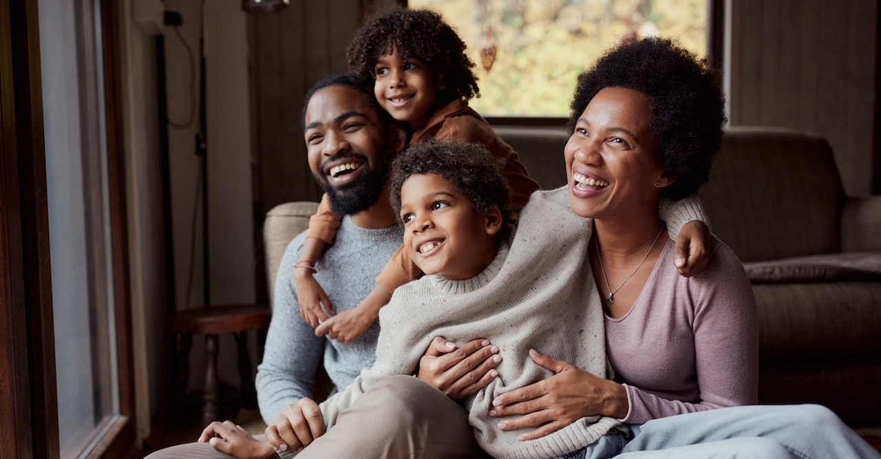 Happy family sitting on couch parents and kids