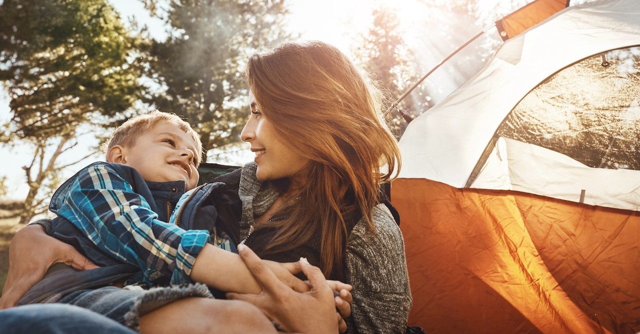 Single mom camping outside with son