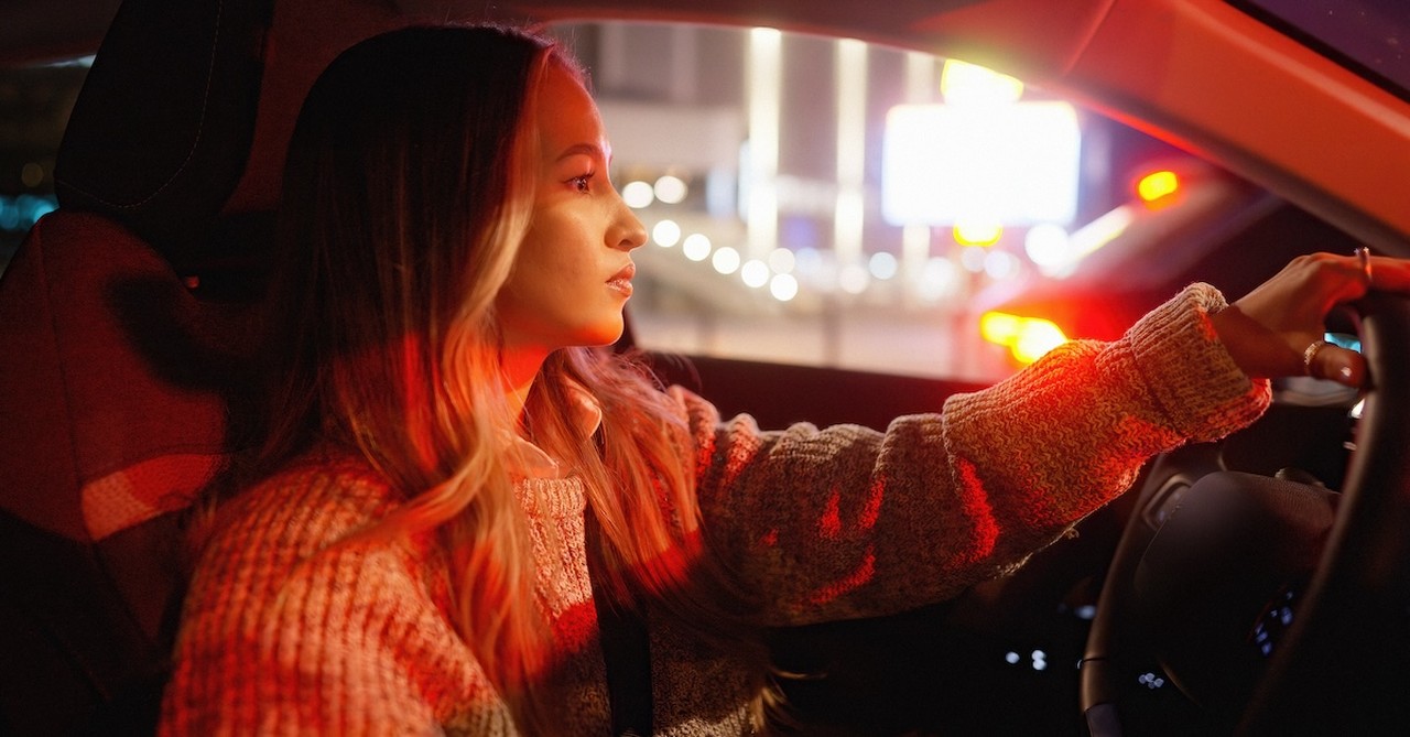 Woman driving in car at stop light