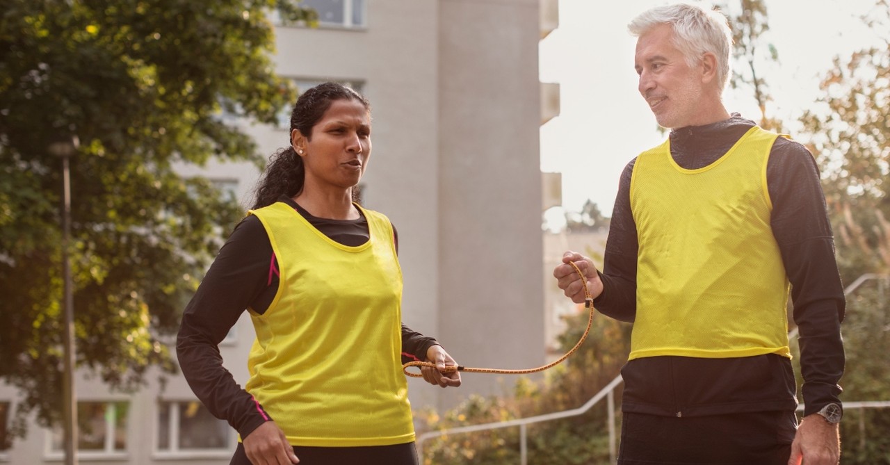 A blind runner talking with the man guiding her