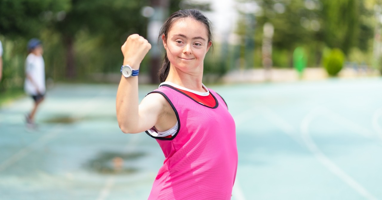 A young woman with Down's syndrome, posing, flexing