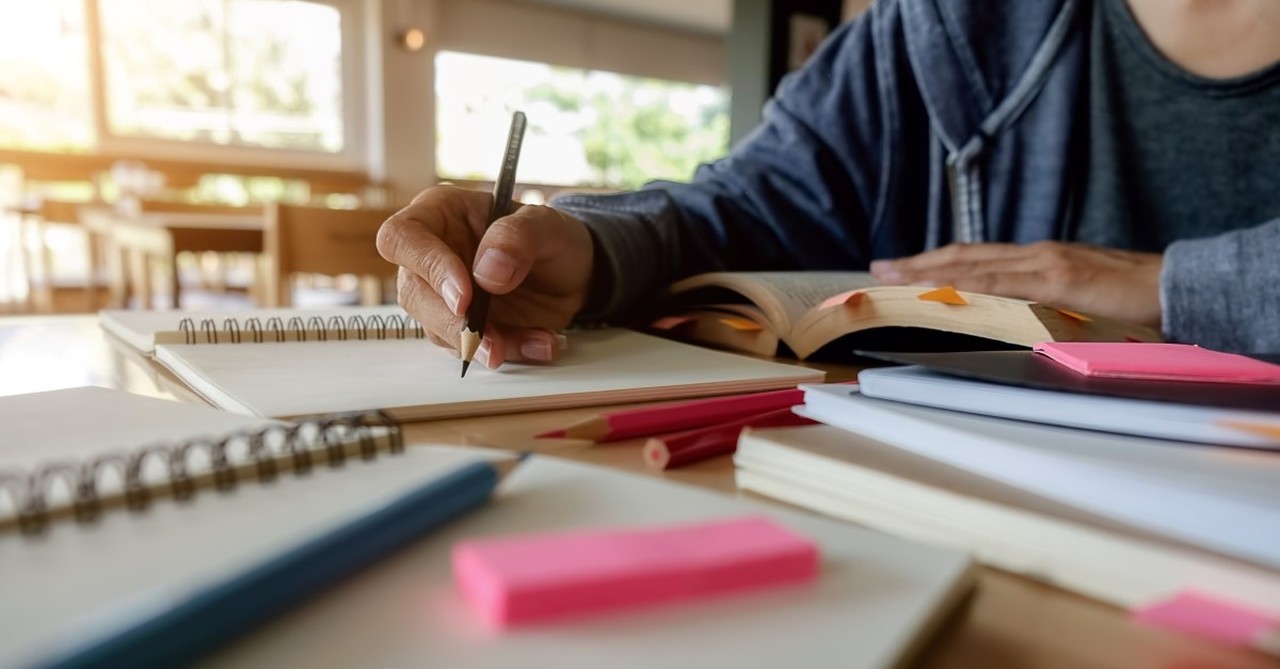 man writing with lots of textbooks and notepads, things i wish i knew when i started christian writing