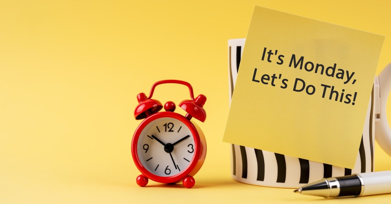 A clock and a sticky note that says "it's Monday, let's do this!"