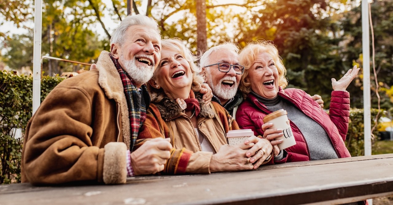 Happy seniors friends in fall outside at park laughing