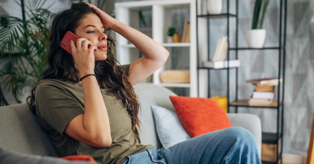 Woman at home on the phone on couch stressed calling