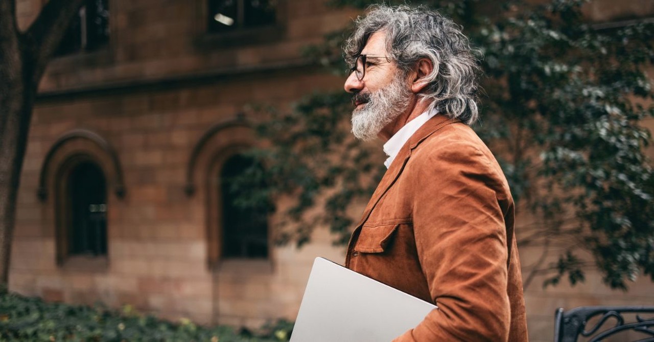 Man walking with laptop; elderly business man; pastor