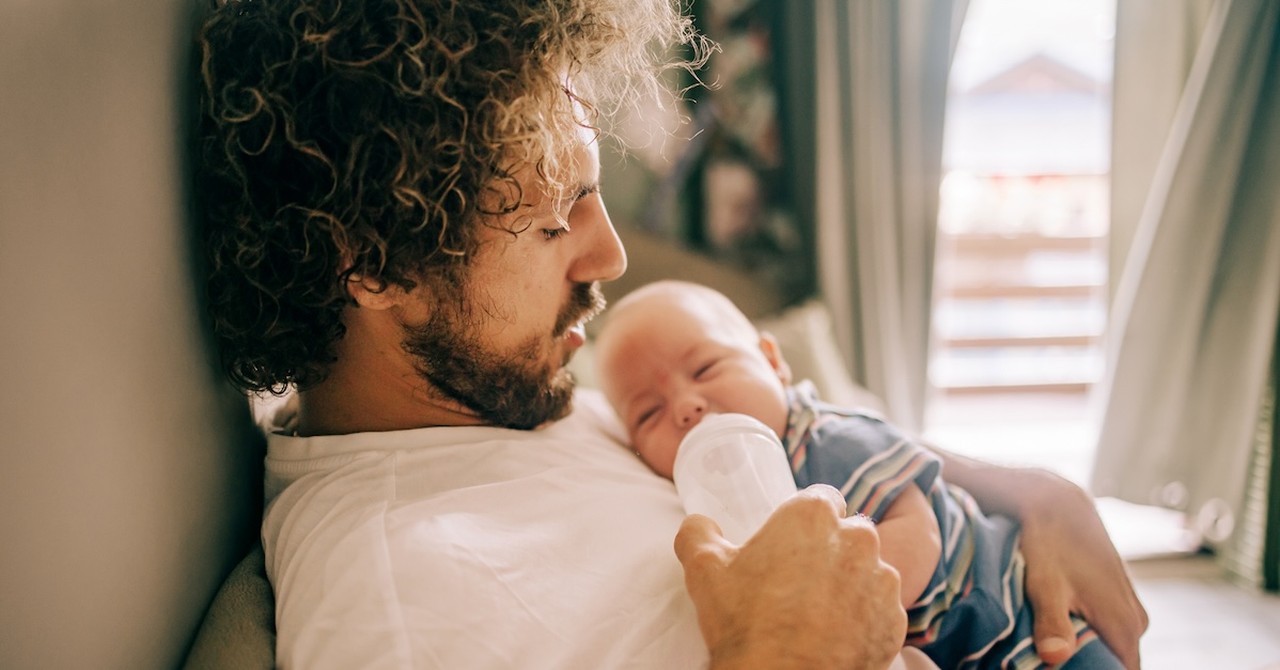Dad feeding newborn baby bottle