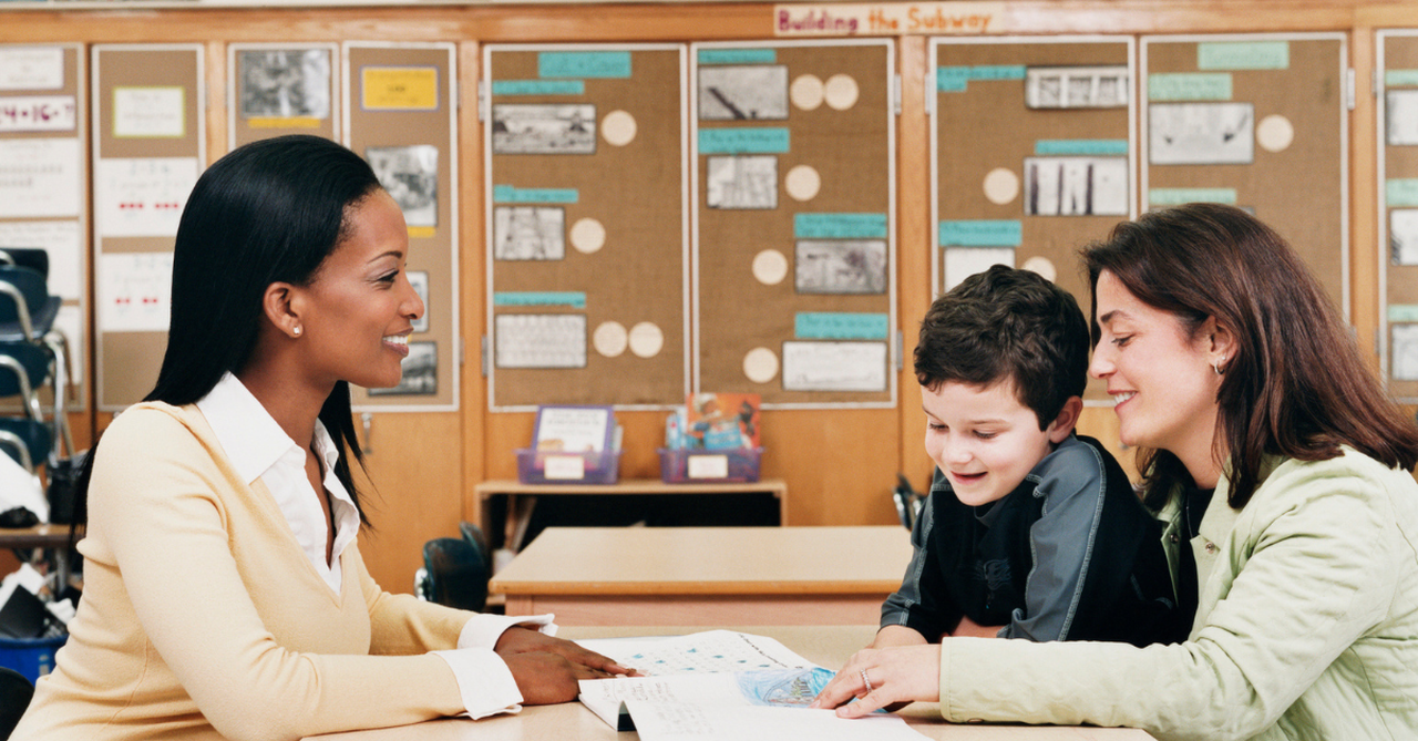 Parent and teacher talking calmly in a classroom