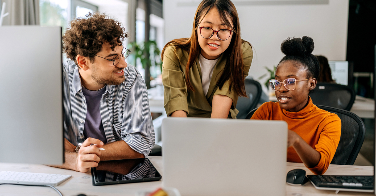 A team collaborating at work, smiling, and sharing ideas.