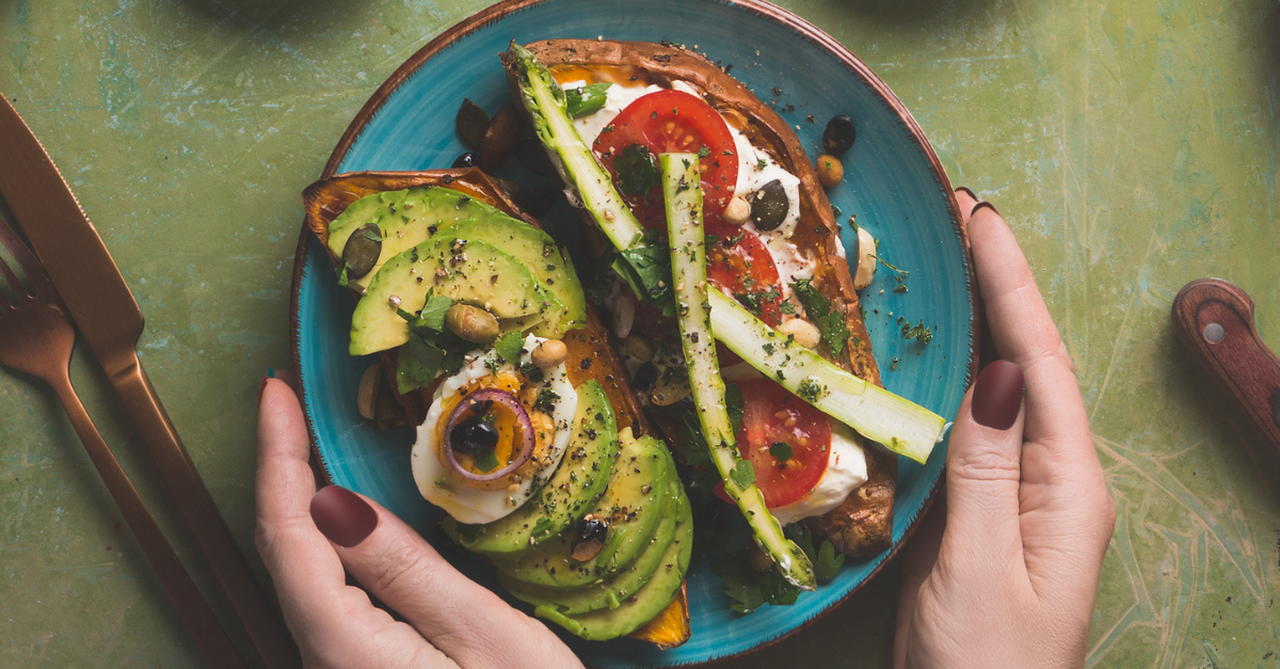 Whole grain toast topped with avocado, cottage cheese, and cherry tomatoes