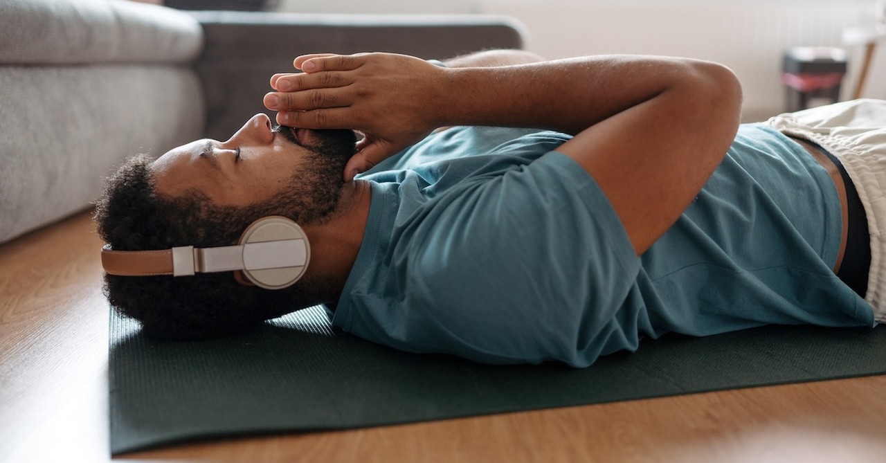 Man doing yoga meditation headphones listening to music