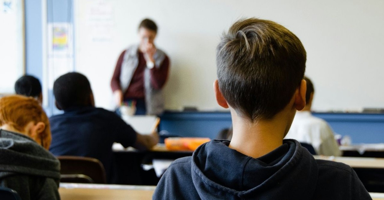 Kids in a classroom listening to their teacher; prayers for when your kids are at school