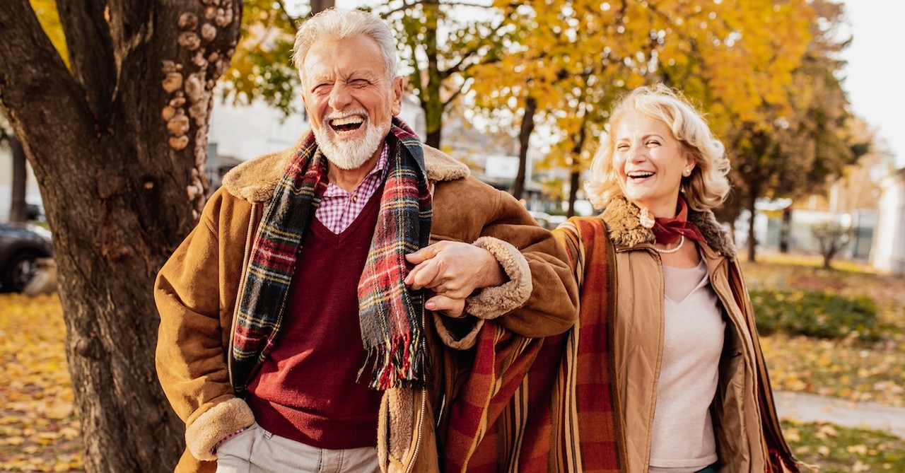 Happy senior couple walking outside fall autumn