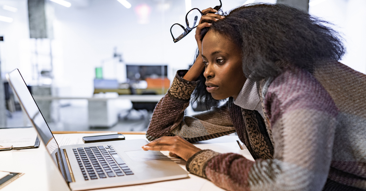 Woman at Computer fidgeting with glasses