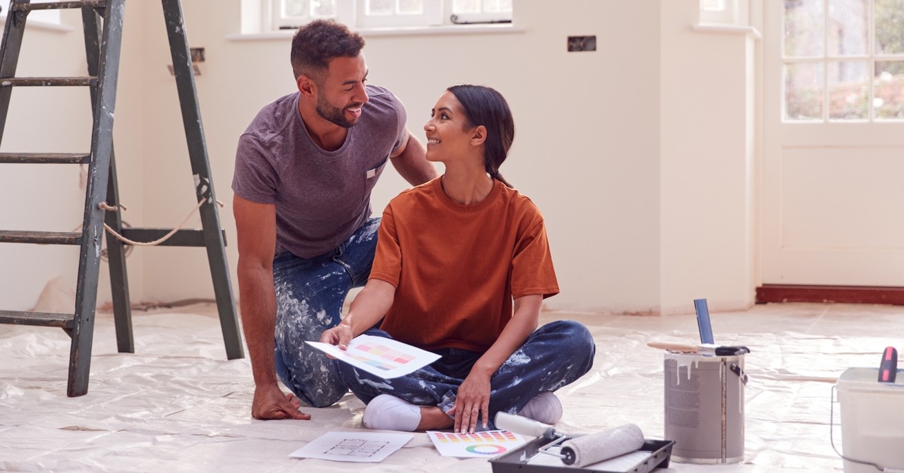 Couple smiling while working on home renovation