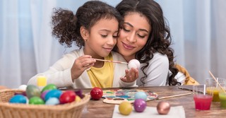 Mom and daughter painting Easter eggs