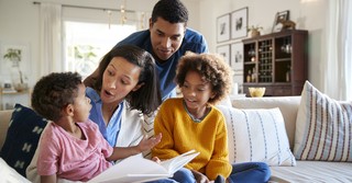 family reading a book together in their living room