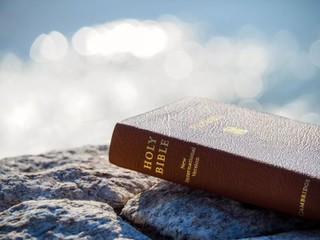 Bible sitting outside on some rocks