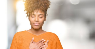 Woman with hands over heart