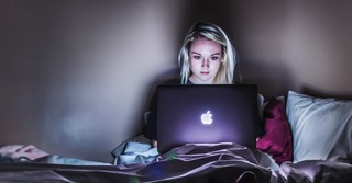 Woman watching TV on laptop in the dark