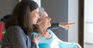 adult daughter caring for elderly senior mom