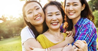 Two grown daughters hugging their mom