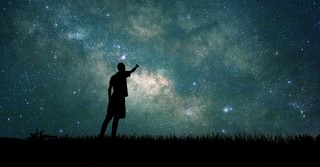 Person pointing up at the stars