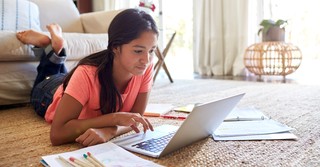 teenage girl working on homework and studying on living room floor, teach teens true definition of success