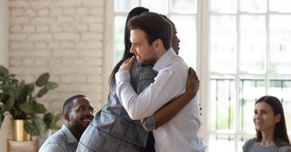 coworkers resolving conflict hugging