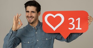 man proud of his social media likes holding heart emoji with 31 in it
