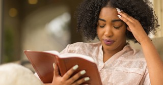 woman upset, thinking while reading the bible