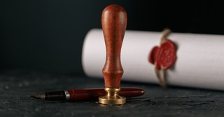 A wax seal stamp and a stamped scroll