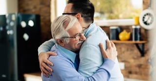 happy senior mature dad hugging prodigal adult son
