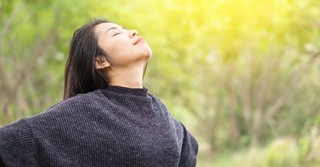 woman eyes closed facing sky, worshipping God