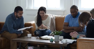 diverse Bible study sitting around coffee table