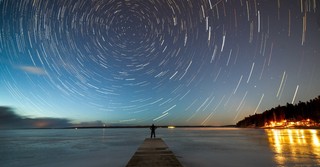 Time-elapse shot of evening stars turning in the sky over a body of water