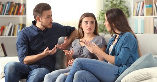three people sitting on couch talking