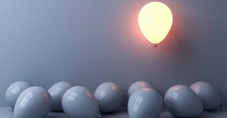 Lighted balloon among gray balloons